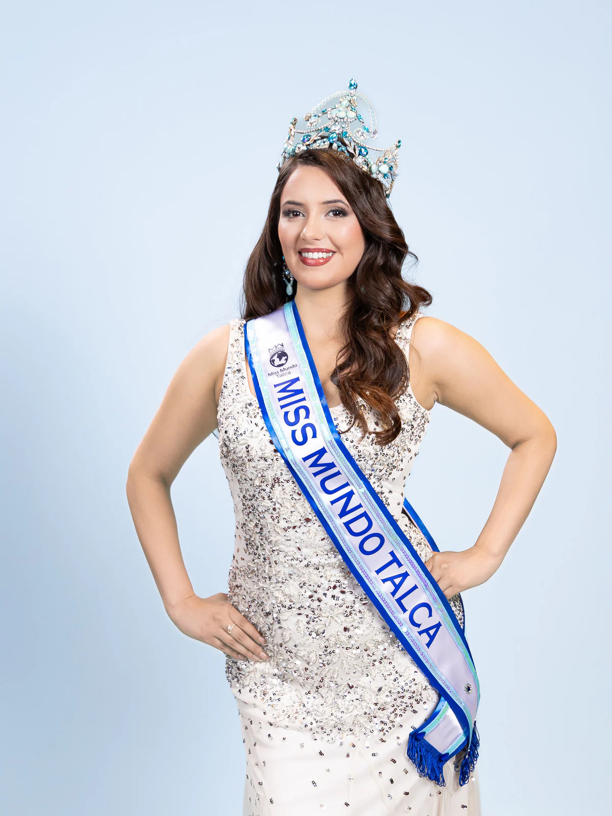 Bárbara Villar de pie con corona y banda de Miss Mundo Talca.