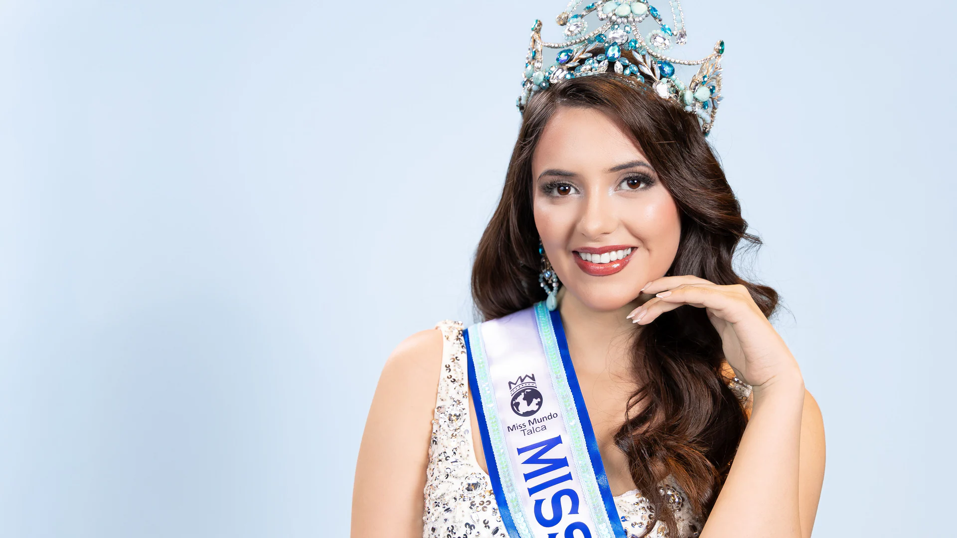 Bárbara Villar con corona y banda de Miss Mundo Talca, retrato de estudio.